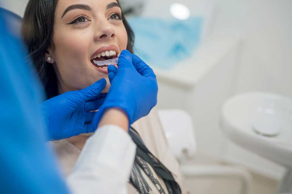 Tandläkare testar tandställning på kvinna