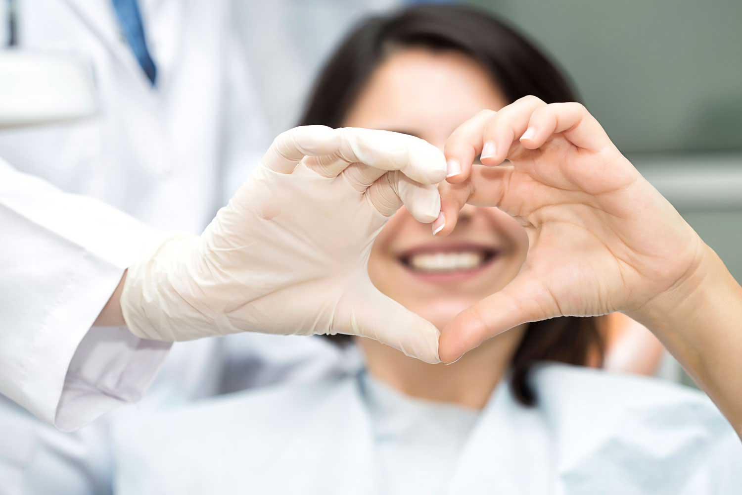 Tandläkare som gör ett hjärta av handen